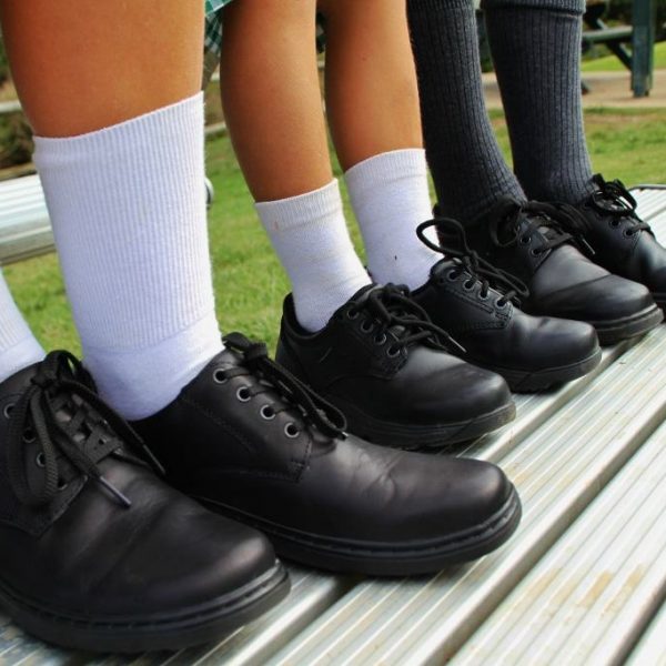 Children's school shoes on a park bench