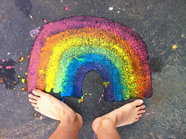 Happy feet standing below a rainbow of colours