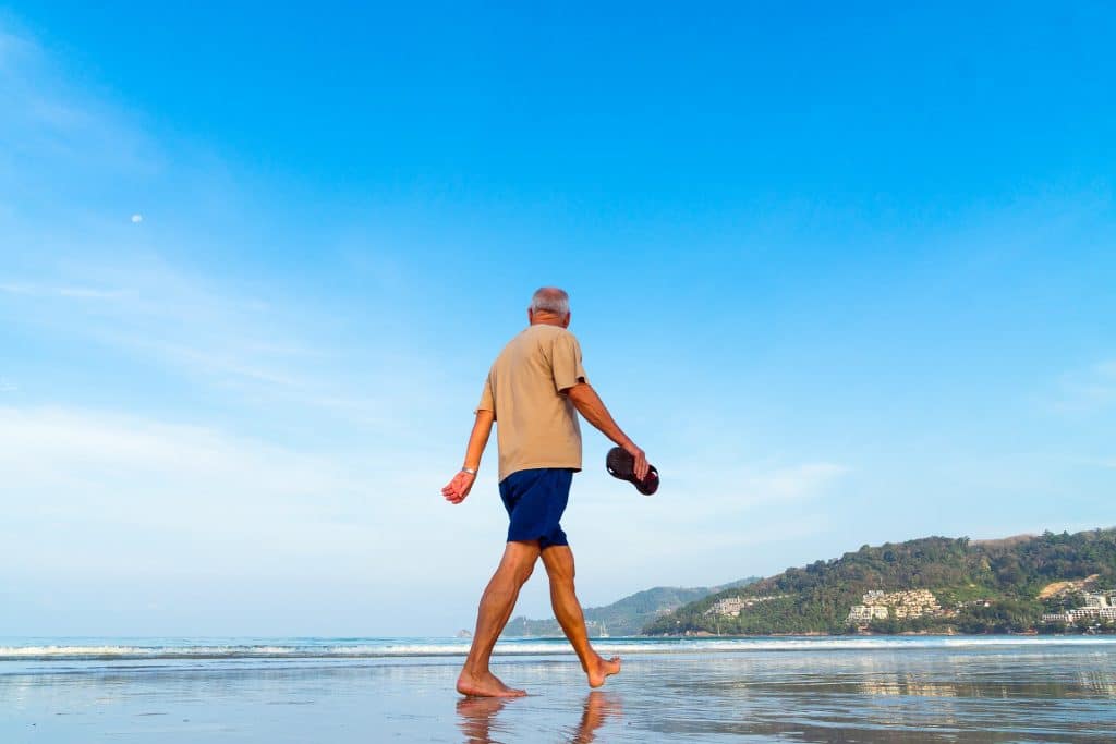 Active senior person walking on beach