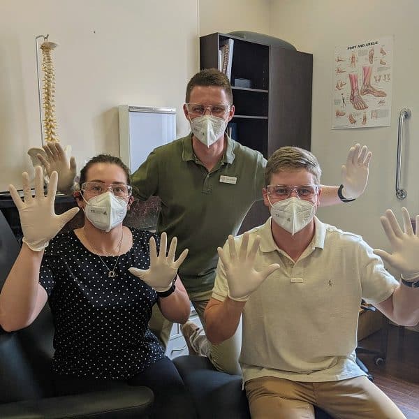 Adelaide Podiatrists, Tess Carey, Tom Kolesnik and Will Duncan sitting on a Posture Podiatry treatment couch.