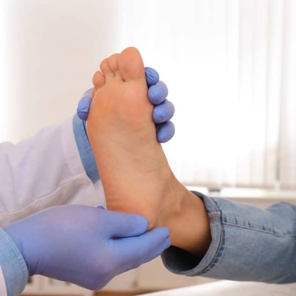 Podiatrist checking the bottom surface of the foot for calluses and pressure lesions