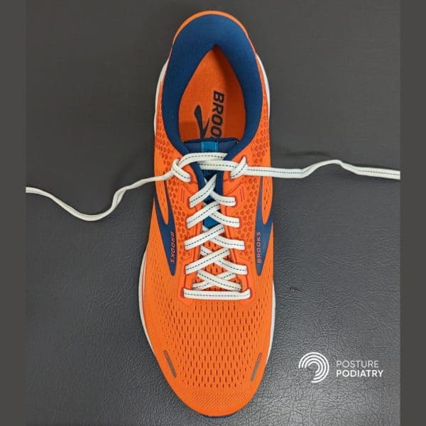 Image displaying orange shoe with loop shoe lacing to help prevent heel slippage