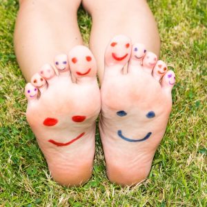 An image displaying two feet with happy faces drawn on them