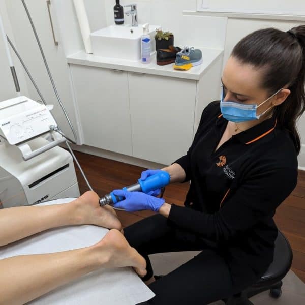 Tessa Coleman Adelaide Podiatrist applying extracorporeal shock wave therapy.