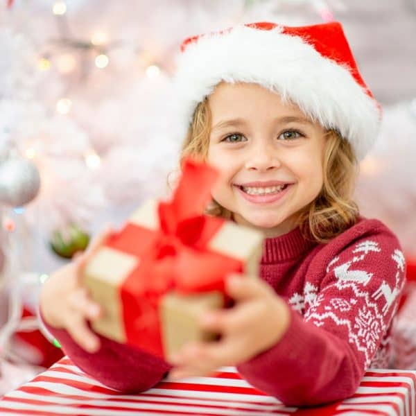 Little girl passing out a Christmas gift