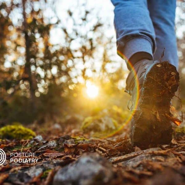 Image of a person's shoe and lower leg walking along a winter trail